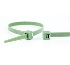 Een groene polypropyleen kabelbinder, chemisch bestendig, naast een uitvergrote sluiting van een andere kabelbinder.