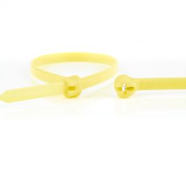 Een gele Ty-Rap® kunststof kabelbinder, naast een uitvergrote sluiting van een andere Ty-Rap® kabelbinder.