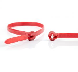 Een rode Ty-Rap® kunststof kabelbinder, naast een uitvergrote sluiting van een andere Ty-Rap® kabelbinder.