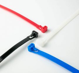 Een witte, een zwarte, een rode en een blauwe hersluitbare kabelbinder op een witte achtergrond.