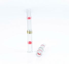 Twee rode, warmtekrimpende, soldeerverbinders, geïsoleerd, één rechtop staand en één liggend, op een witte achtergrond.