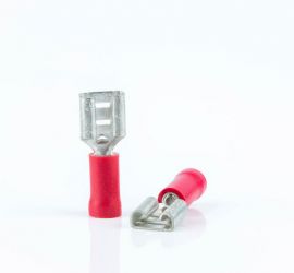 Twee rode geïsoleerde vlakstekerhulzen, zonder huls, één rechtop staand en één liggend, op een witte achtergrond.